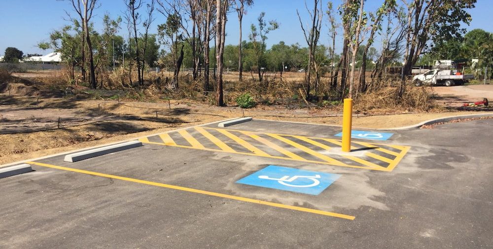 A Handicapped Parking Spot in a Parking Lot With Trees in the Background — Diggamen Civil Contracting in Tivendale, NT