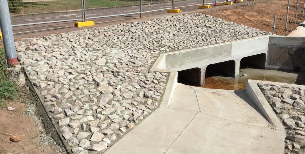 A Large Pile of Rocks is Sitting on Top of a Concrete Surface — Diggamen Civil Contracting in Tivendale, NT