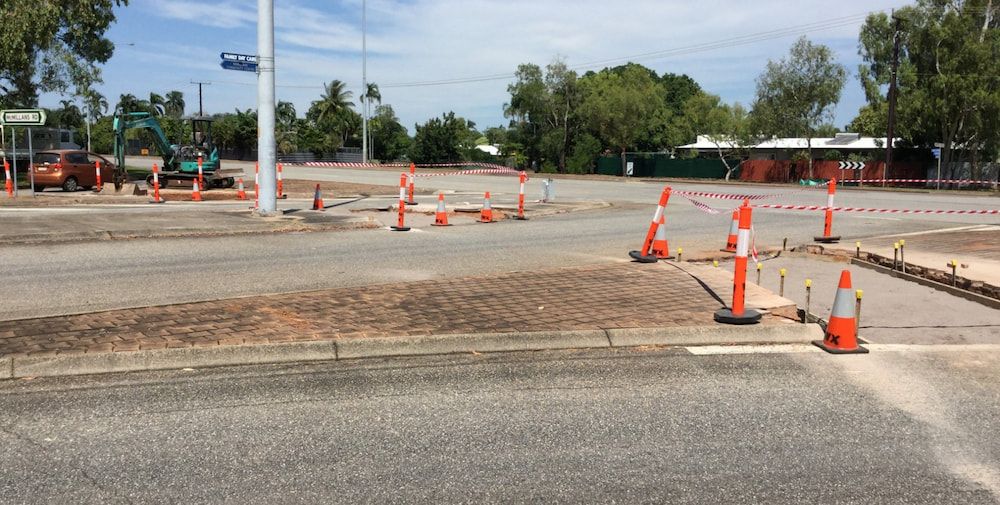 A Lot of Orange and White Traffic Cones Are on the Side of the Road — Diggamen Civil Contracting in Tivendale, NT