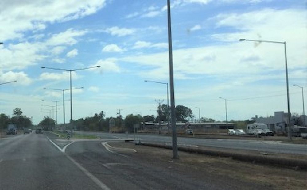 A Car is Driving Down a Road With a Chevron Sign on the Side of the Road — Diggamen Civil Contracting in Tivendale, NT