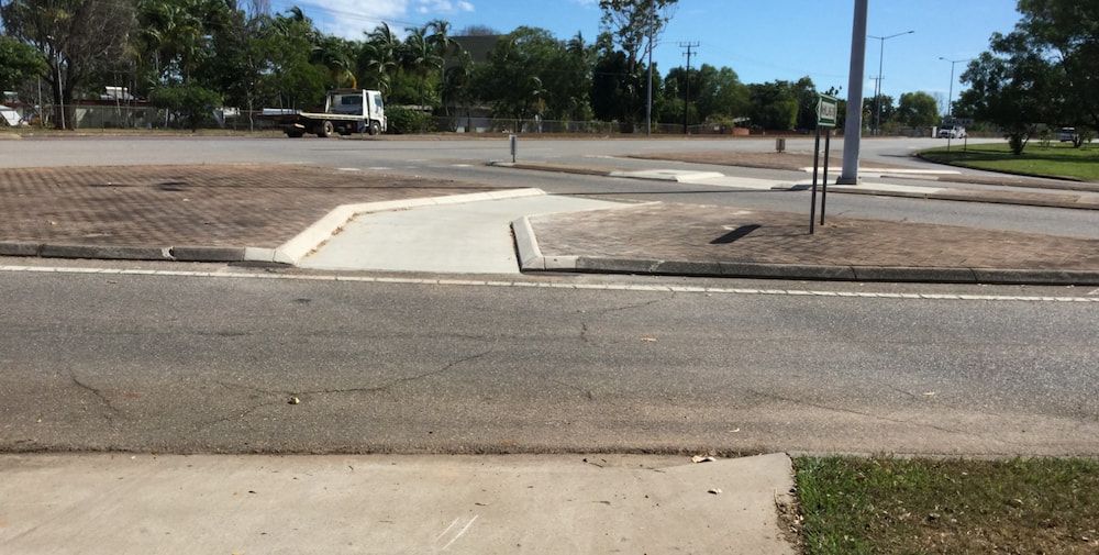 A Truck is Driving Down a Road Next to a Sidewalk — Diggamen Civil Contracting in Tivendale, NT