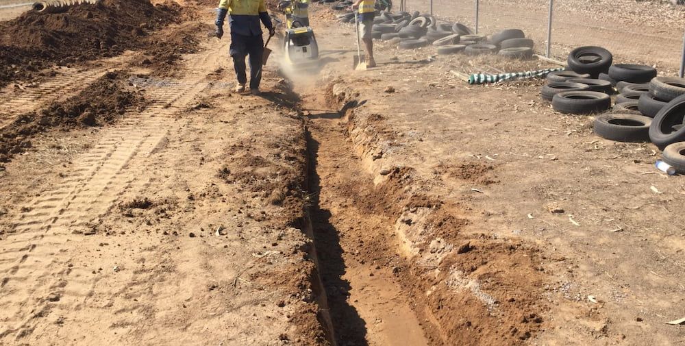 A Group of Construction Workers Are Digging a Trench in the Dirt — Diggamen Civil Contracting in Tivendale, NT