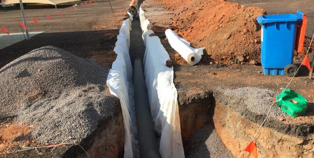 A Blue Trash Can is Sitting Next to a Pile of Dirt — Diggamen Civil Contracting in Tivendale, NT
