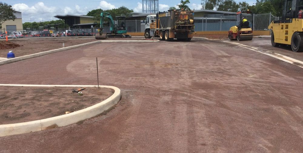 A Group of Construction Vehicles Are Working on a Road — Diggamen Civil Contracting in Tivendale, NT