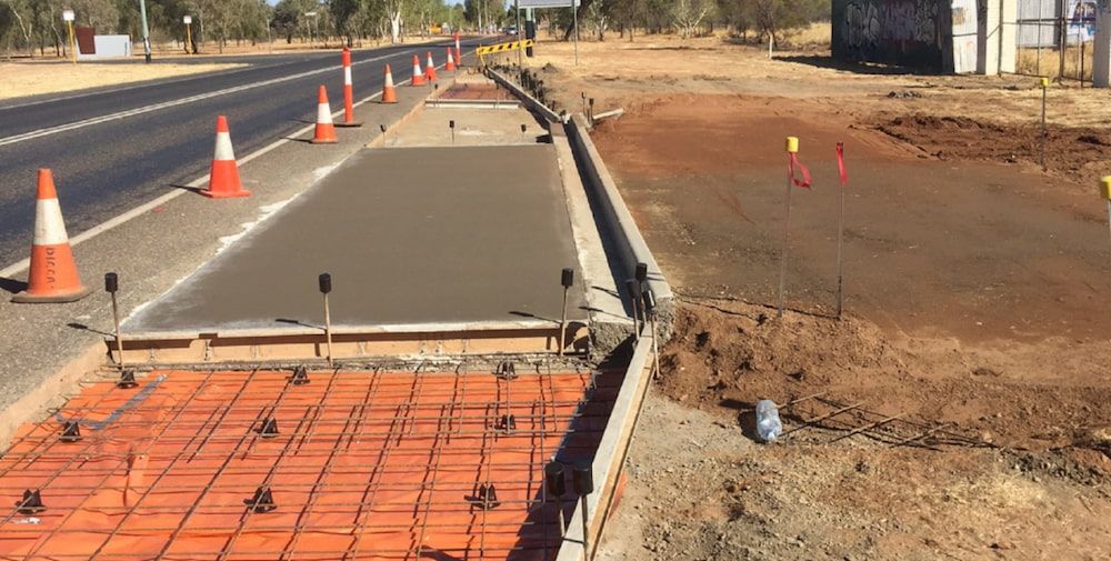 A Concrete Walkway is Being Built Next to a Highway — Diggamen Civil Contracting in Tivendale, NT