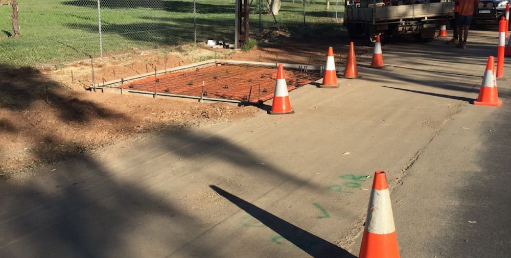 A Row of Orange and White Traffic Cones on the Side of a Road — Diggamen Civil Contracting in Tivendale, NT