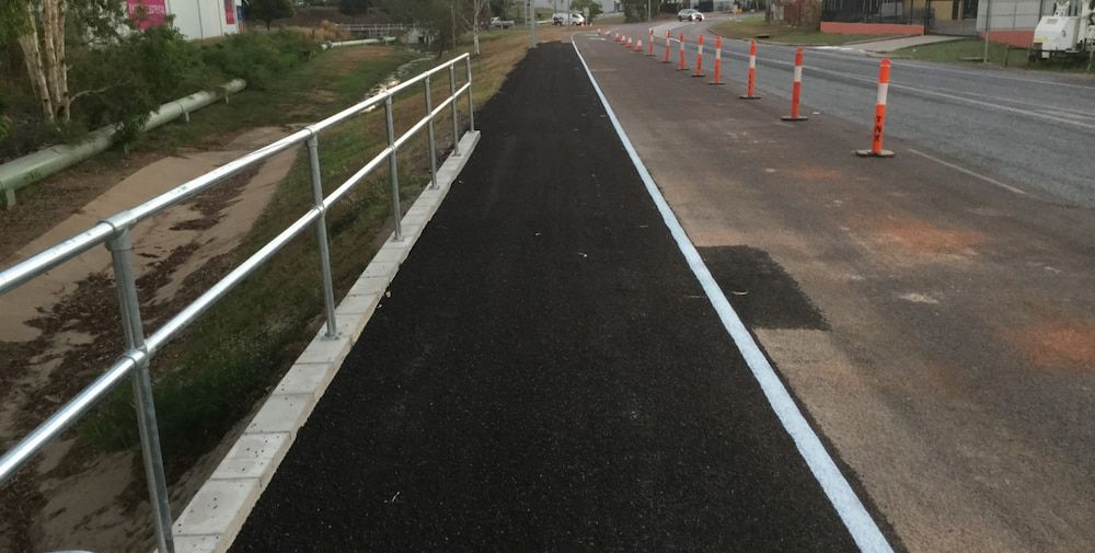A Road With a Metal Railing on the Side of It — Diggamen Civil Contracting in Tivendale, NT