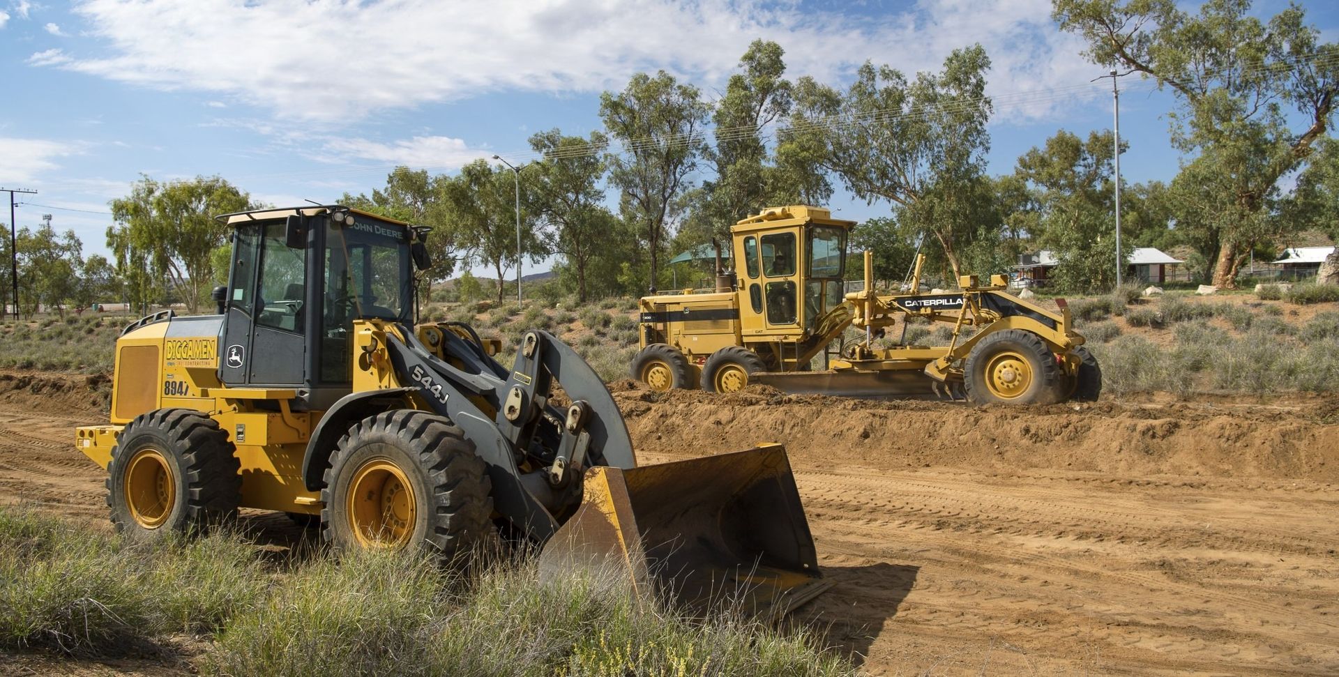 Two yellow bulldozers are parked on dirt — Diggamen Civil Contracting in Tivendale, NT