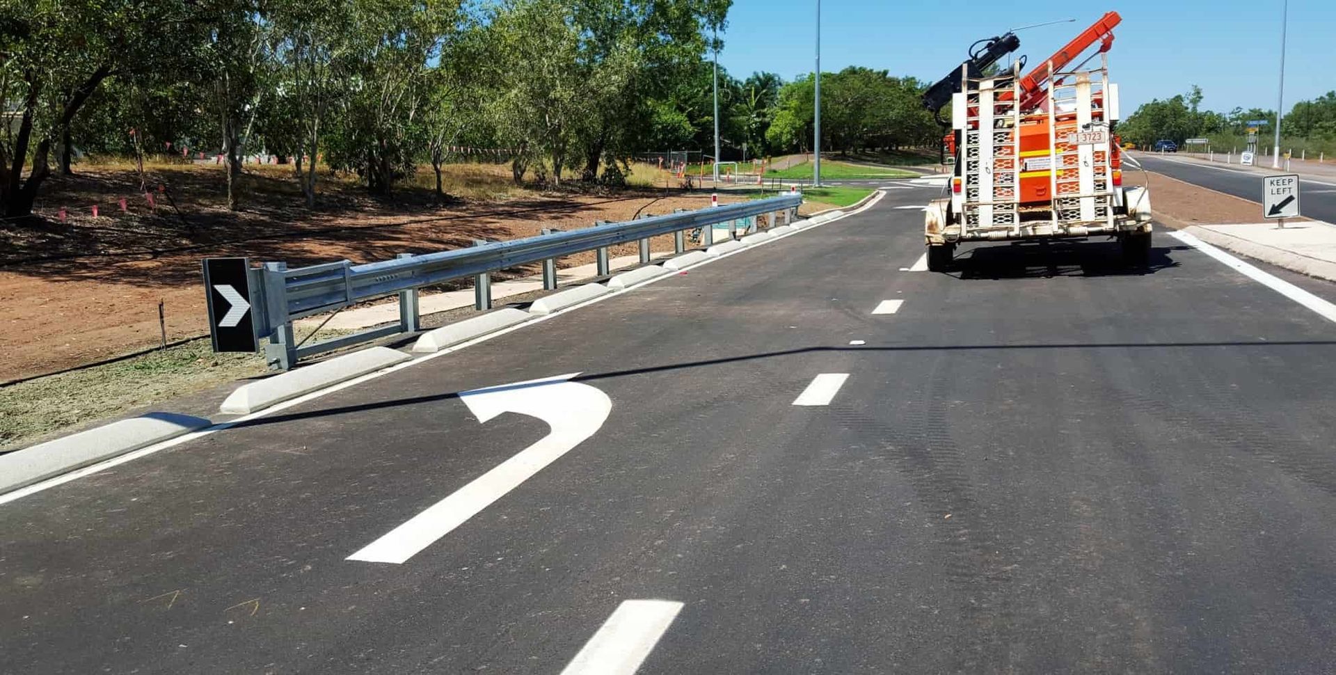 A Truck Is Painting a White Arrow on The Side of A Road — Diggamen Civil Contracting in Jabiru, NT