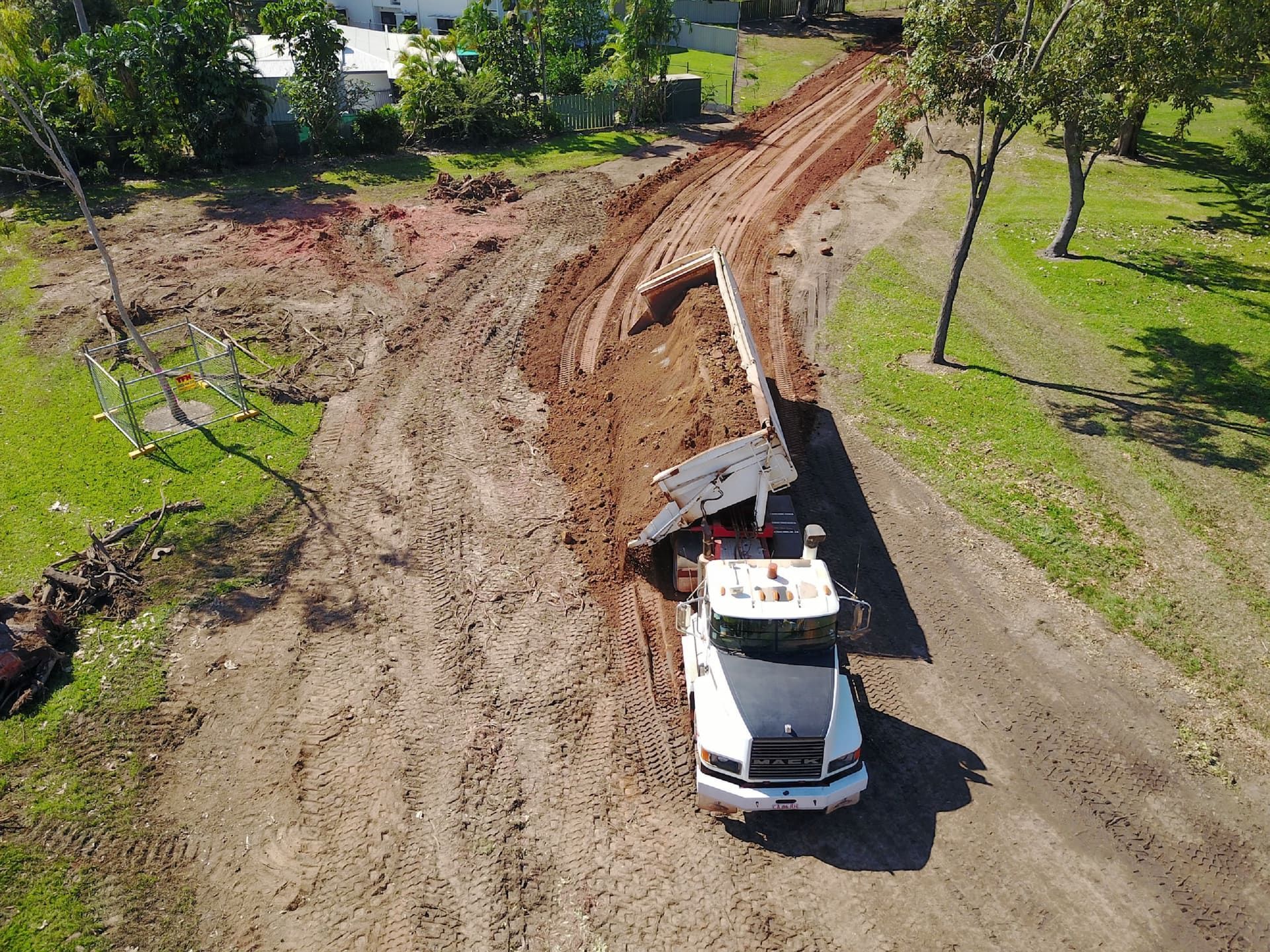 An Aerial View of A Dump Truck Driving Down a Dirt Road — Diggamen Civil Contracting in Jabiru, NT