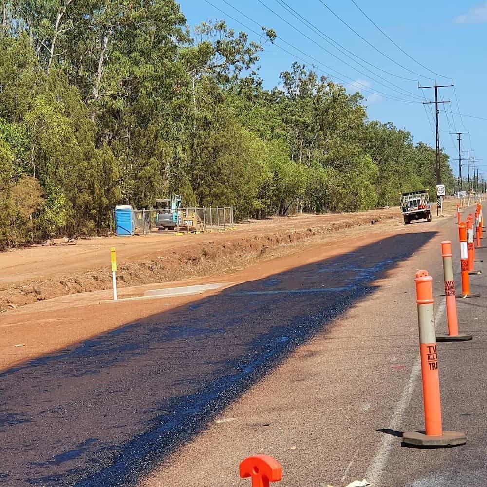 A Row of Orange and White Safety Cones on The Side of A Road — Diggamen Civil Contracting in Tivendale, NT
