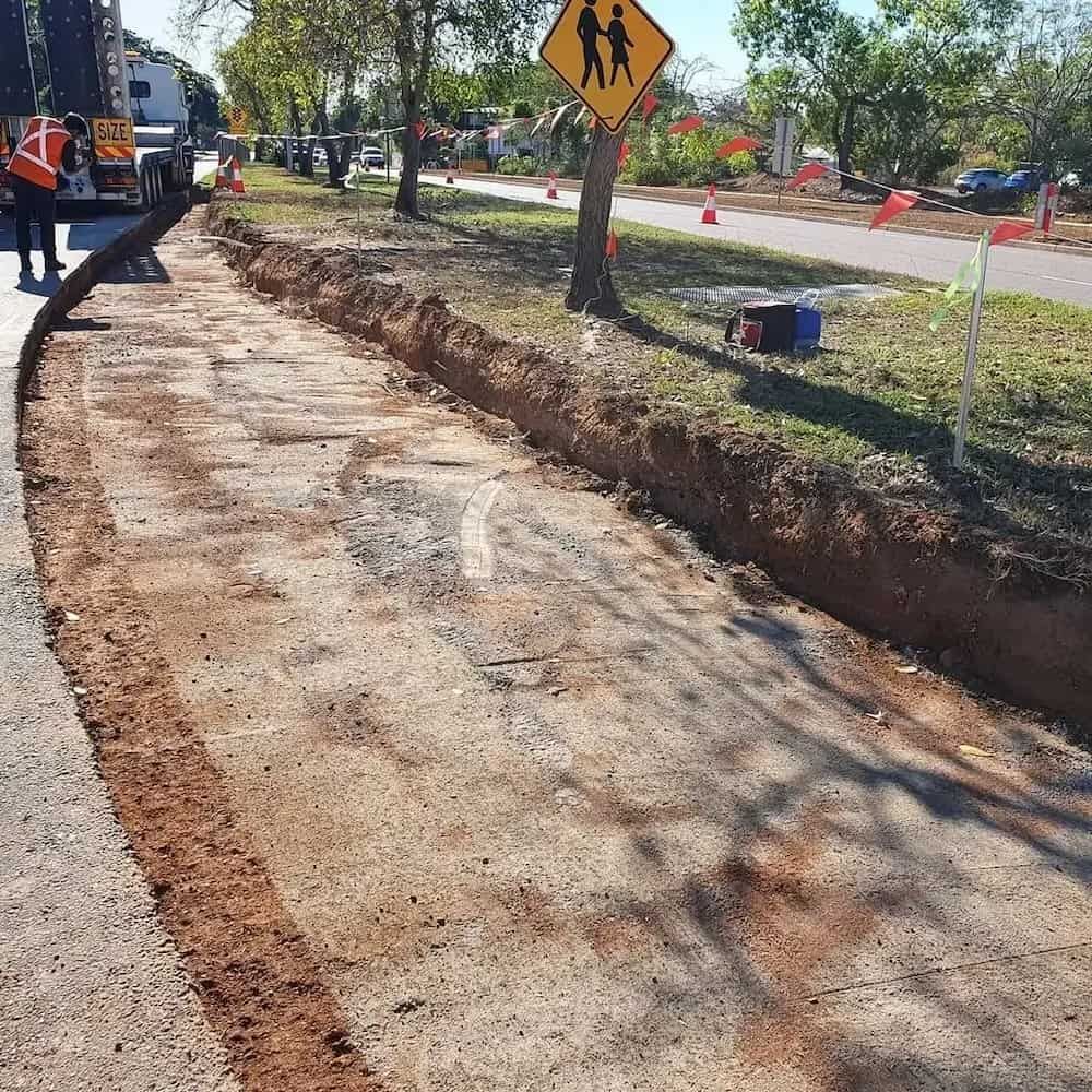 A Yellow School Crossing Sign Is Sitting on The Side of A Road — Diggamen Civil Contracting in Tivendale, NT