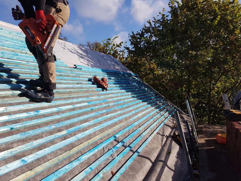 A man is working on the roof of a building.