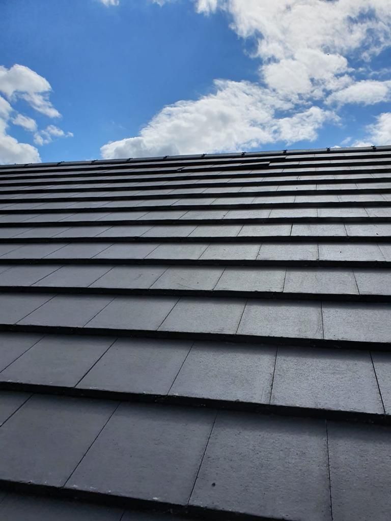 A close up of a roof with a blue sky in the background