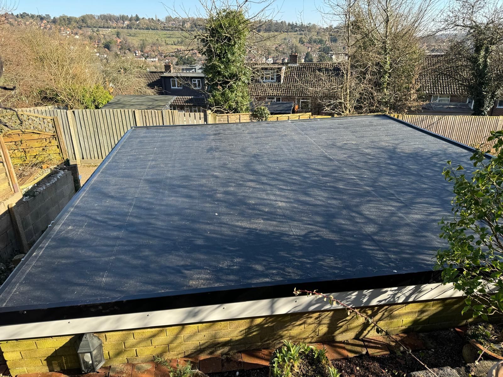 A black roof is sitting on top of a brick building.