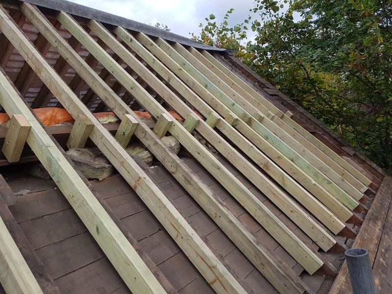 A roof is being built with wooden beams.