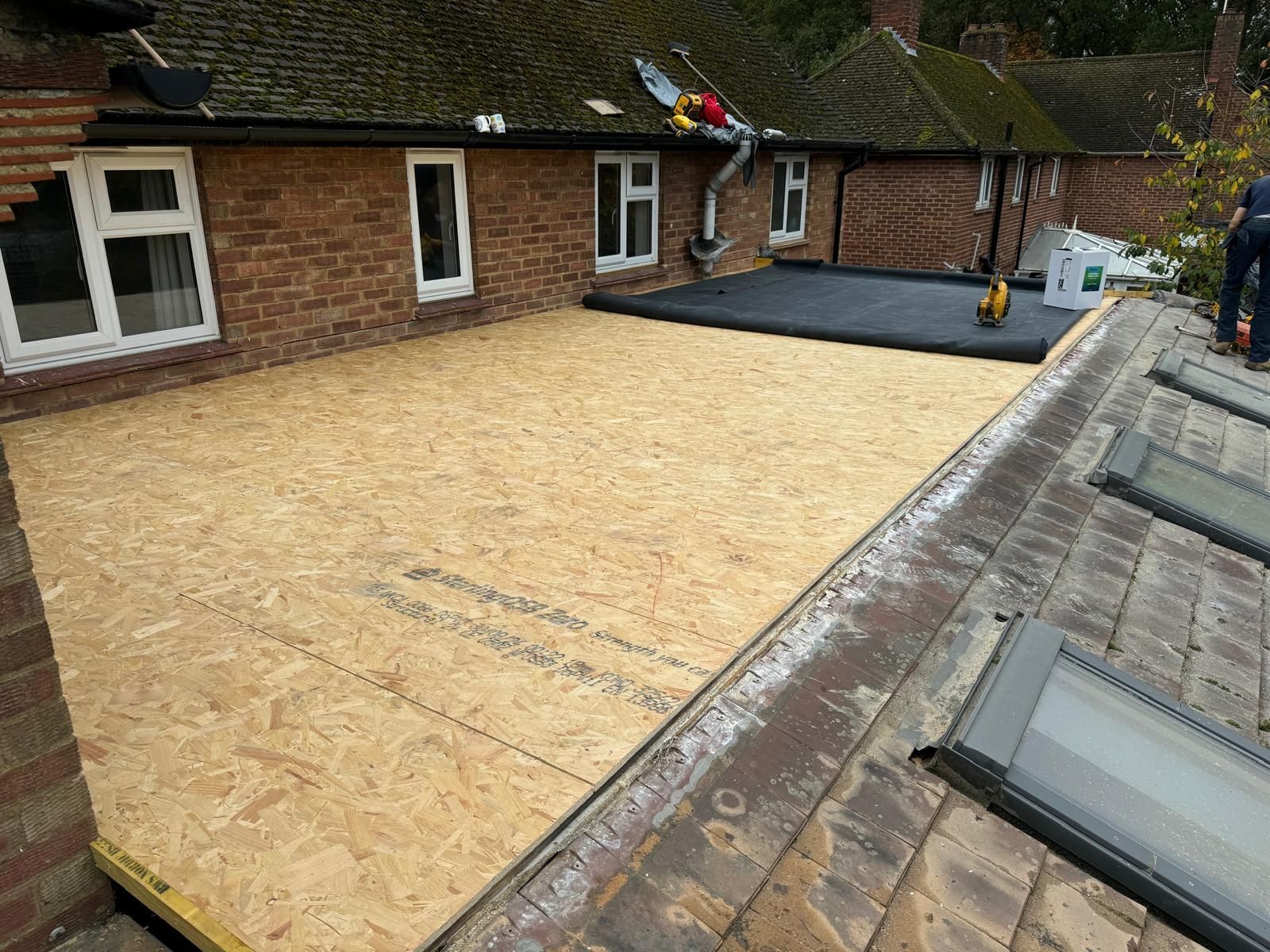 A man is working on the roof of a house.