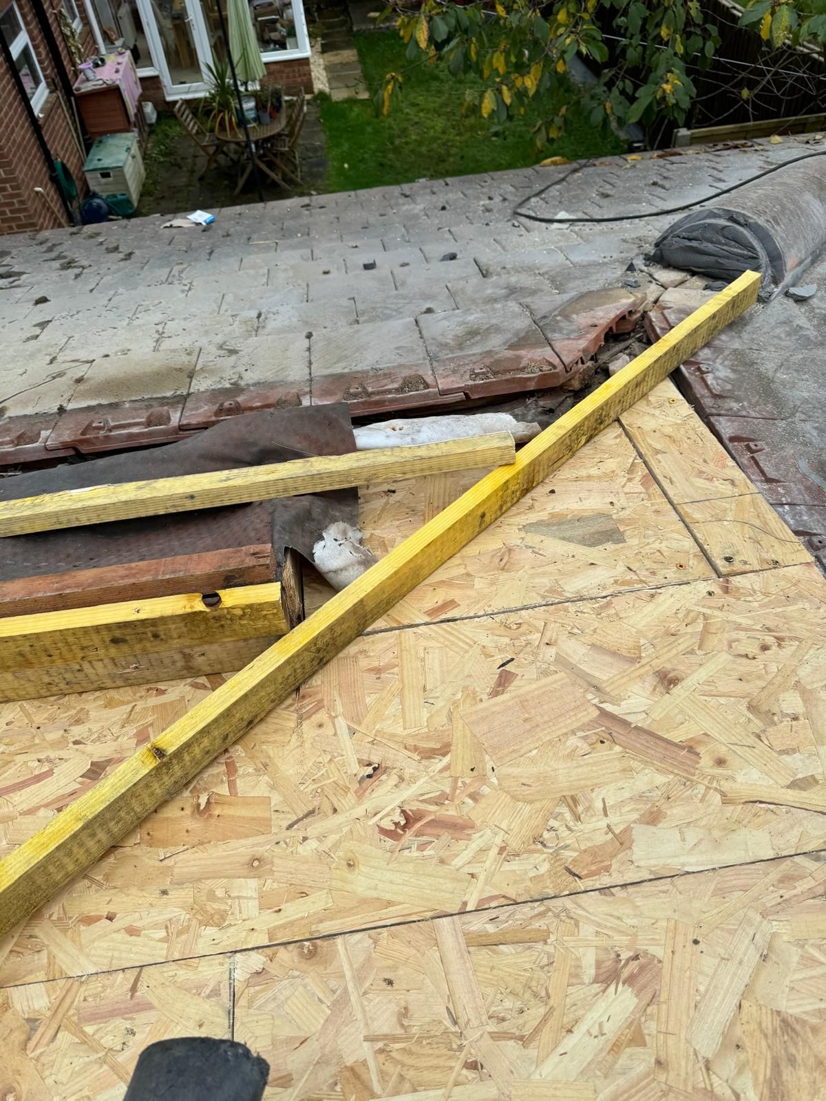 A yellow level is sitting on top of a wooden roof.