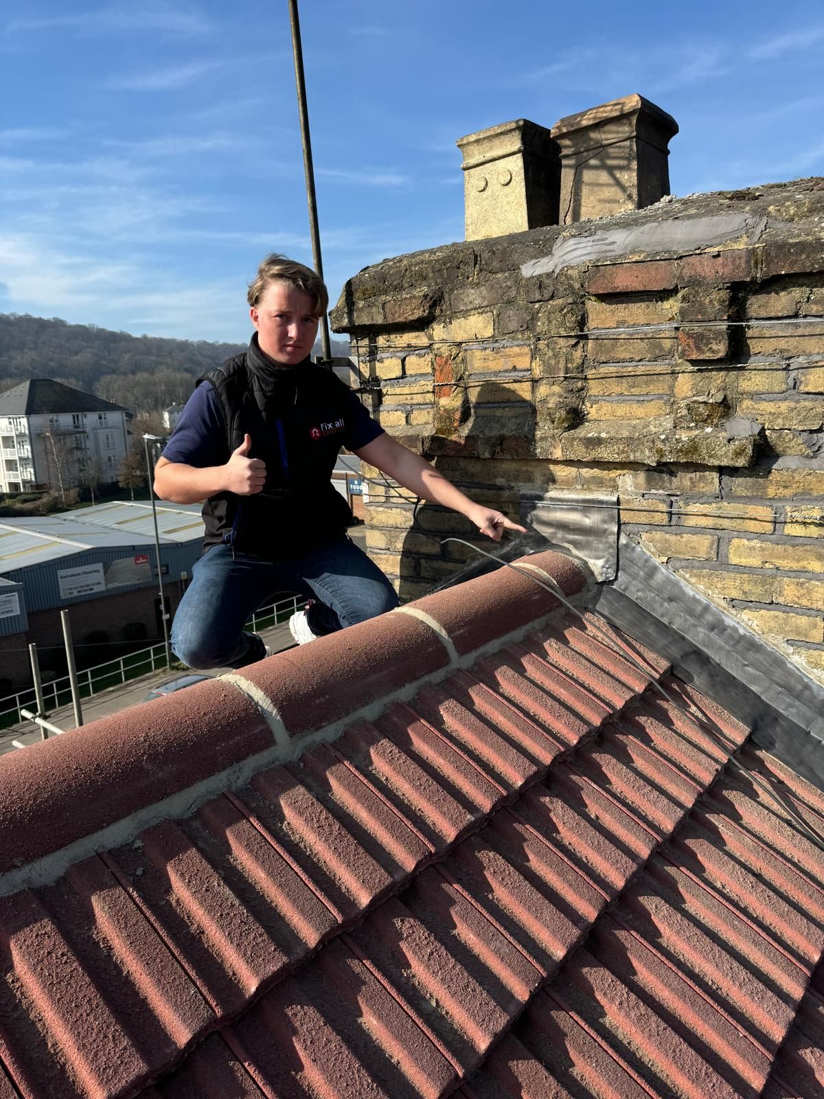 Close-up of a roofing professional conducting an inspection on a traditional tiled roof in a High Wycombe, UK, residential area
