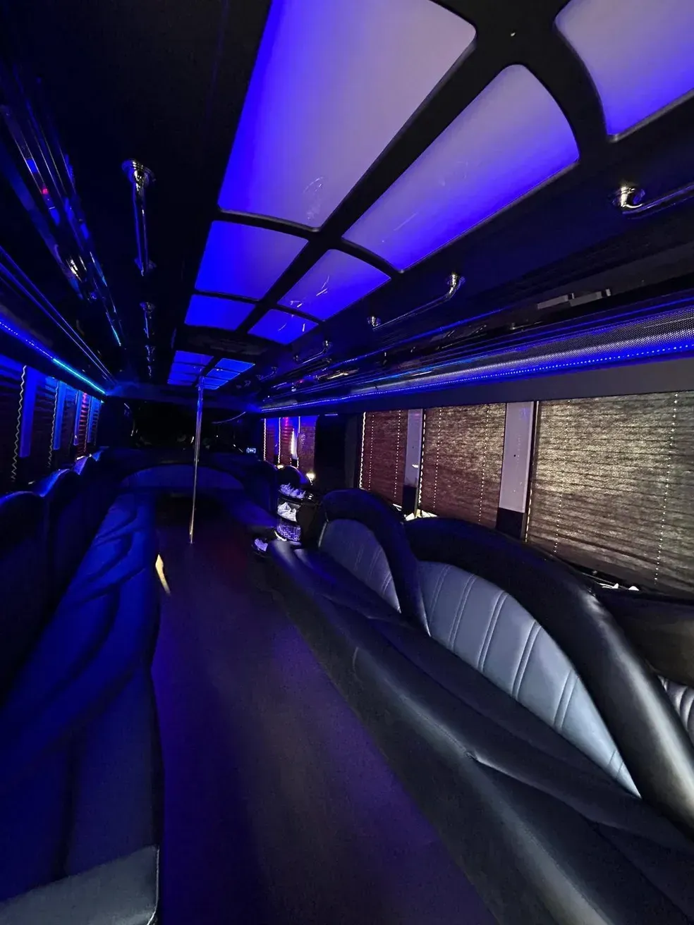The inside of a limousine with blue lights on the ceiling.