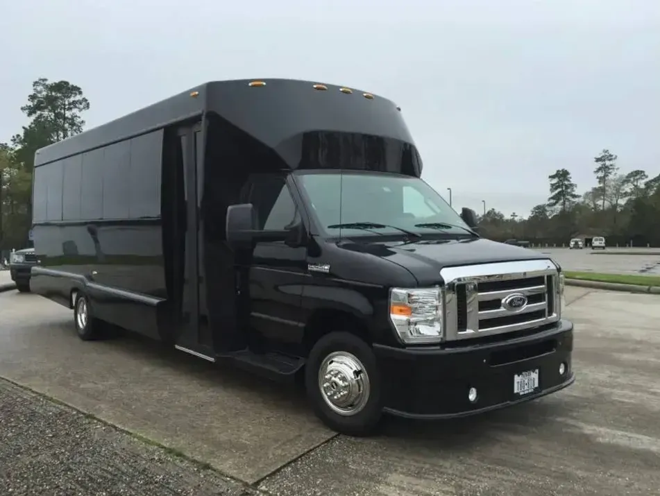 A black shuttle bus is parked on the side of the road.