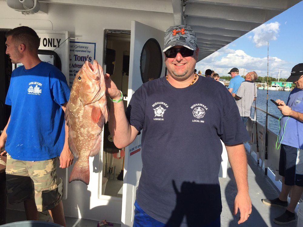 Man Holding Red Fish — Fort Myers, FL — Captain Tony’s Fishing Adventures
