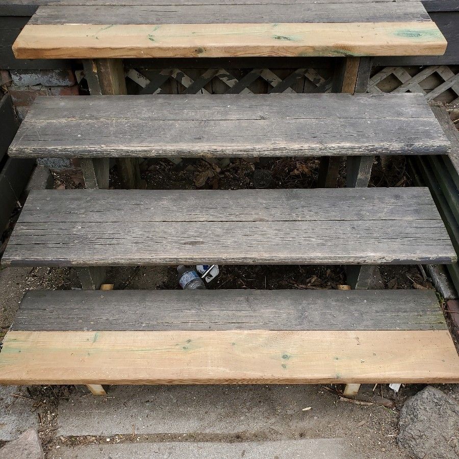 Weathered wooden steps leading up a small outdoor deck or porch