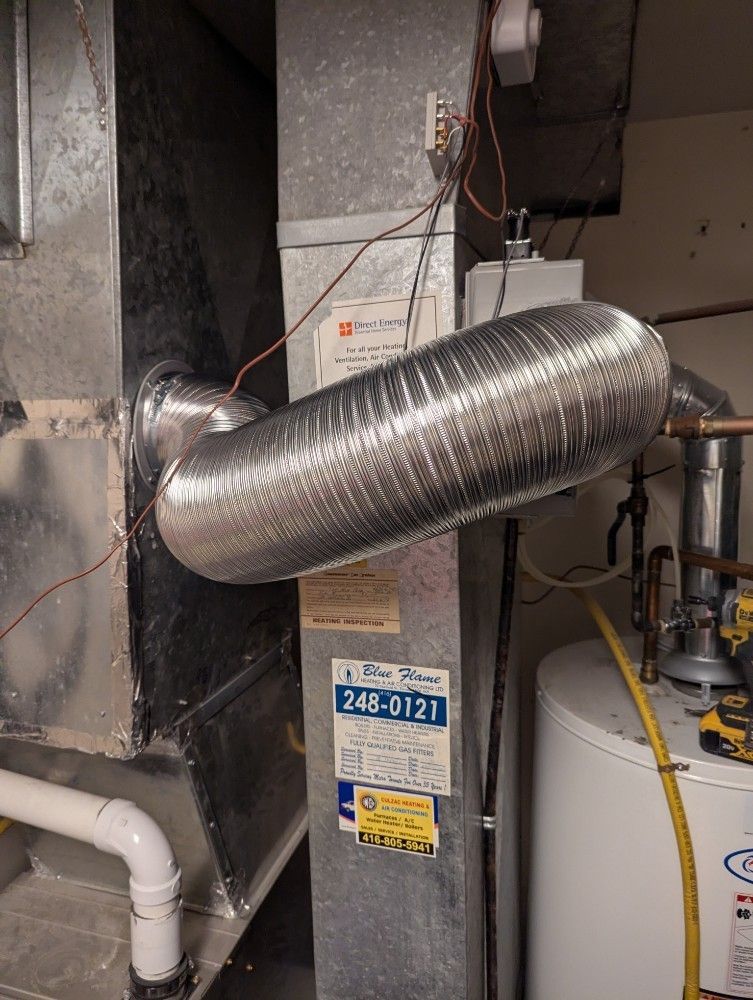 Silver insulated duct connected to HVAC equipment in a utility room with pipes and a water heater.
