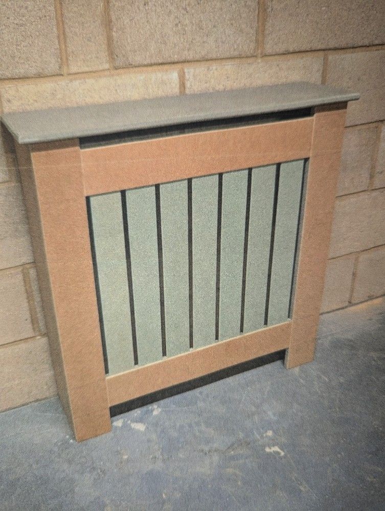 Wooden radiator cover with gray top and green slatted front against a brick wall