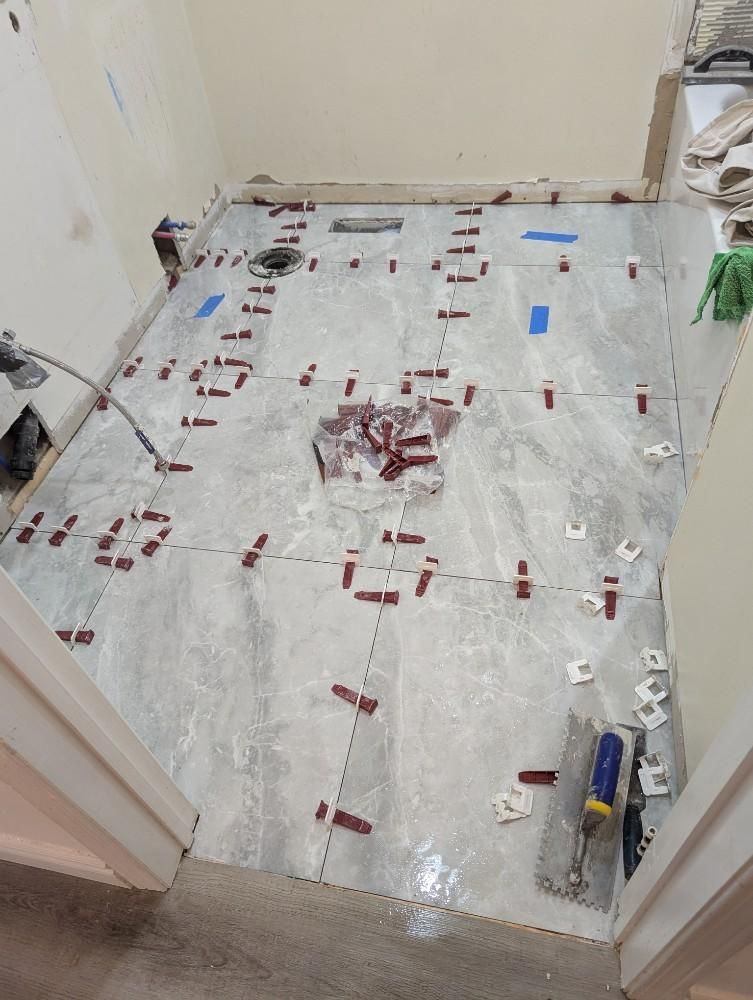 Bathroom floor covered in protective plastic and tape during renovation