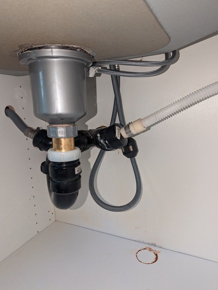 Under-sink plumbing with drain pipe, garbage disposal, and flexible hose connections