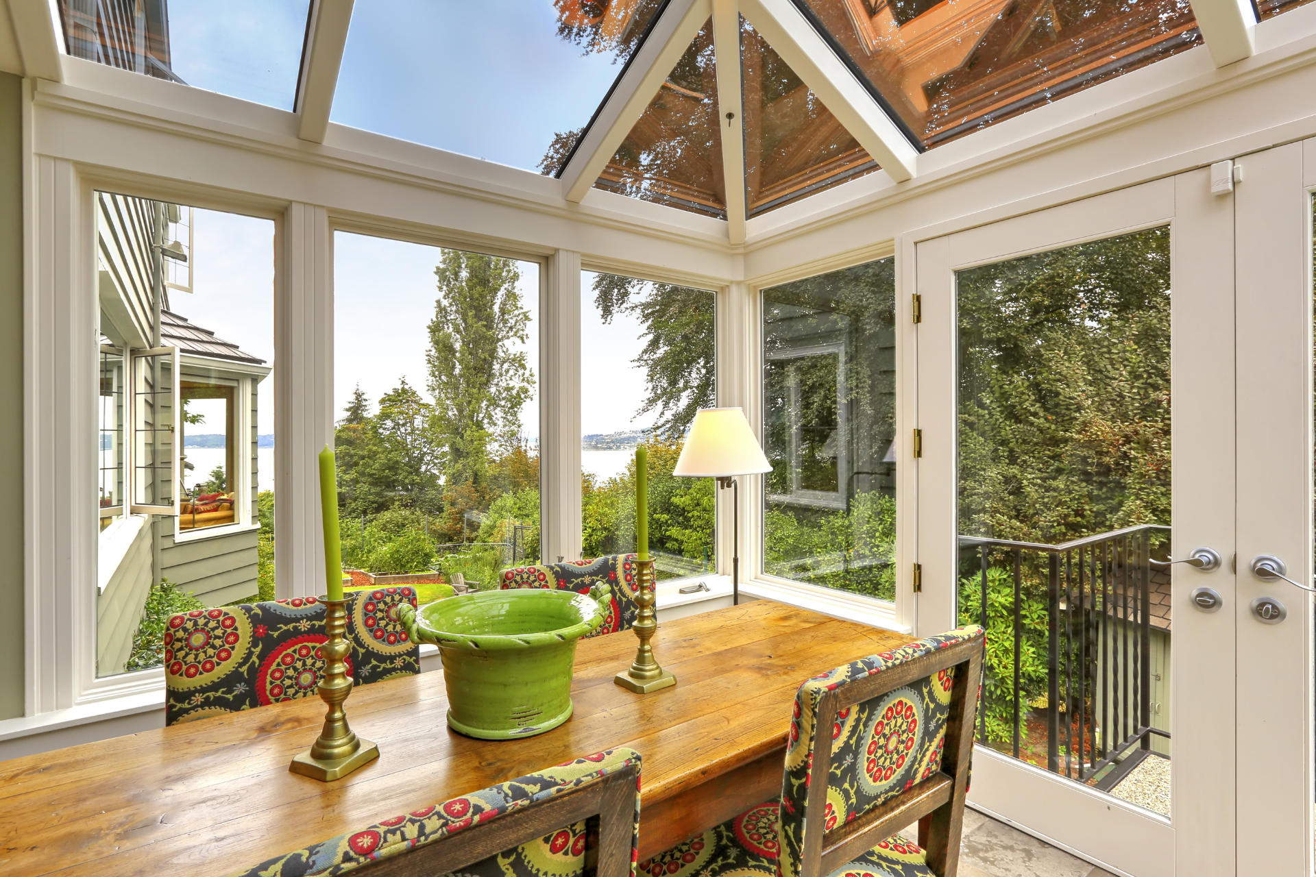 A dining room with a wooden table and chairs and a glass ceiling.