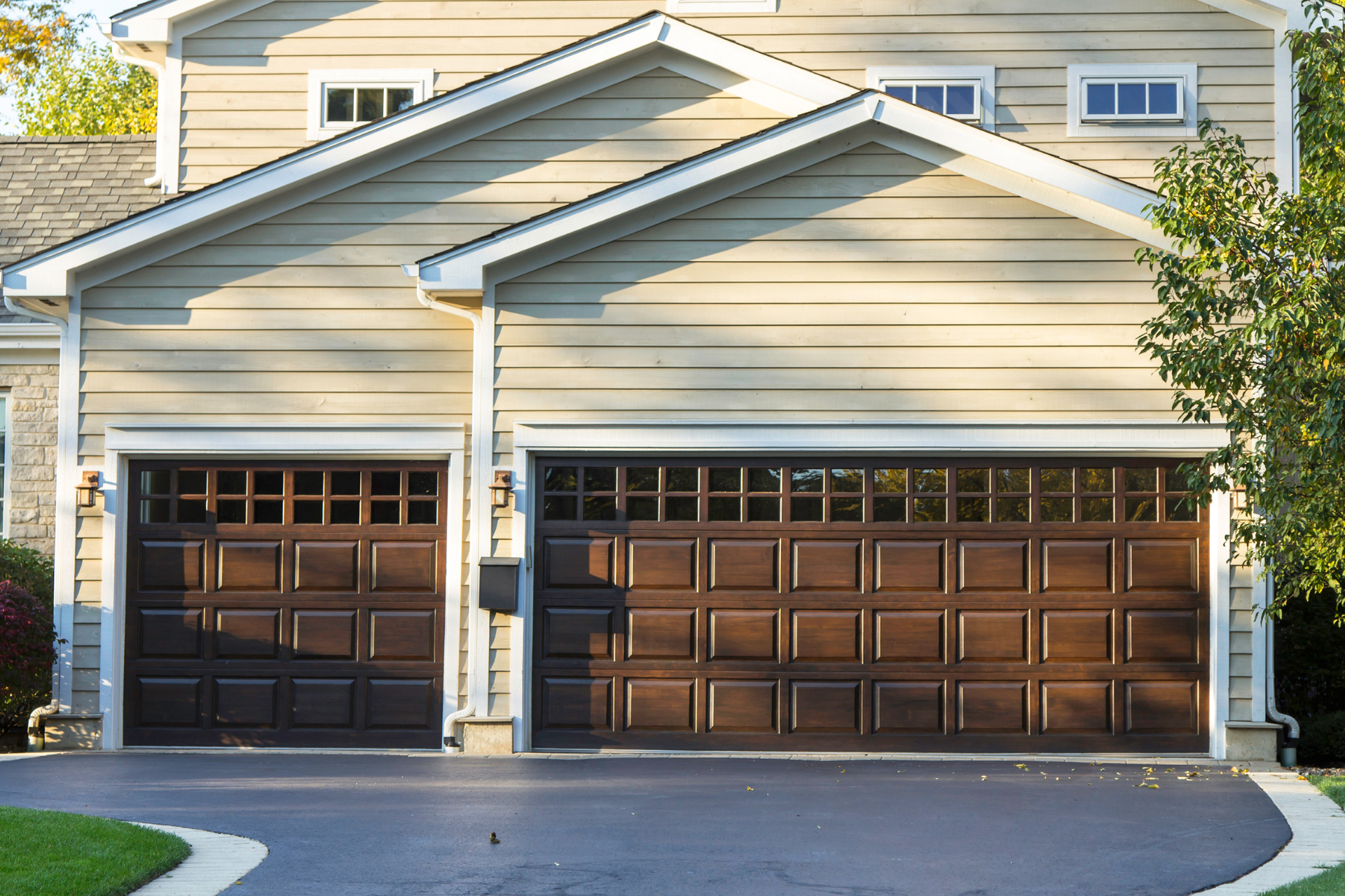 A house with two brown garage doors and a driveway