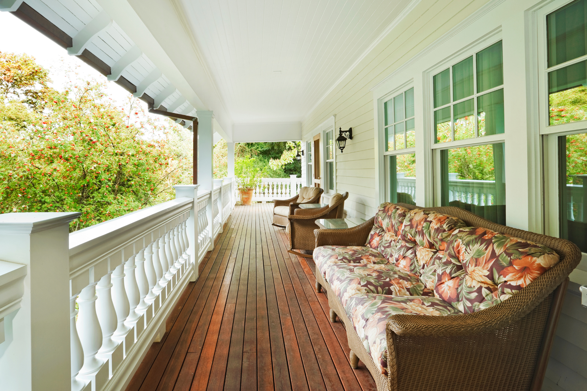A large porch with a couch and chairs on it