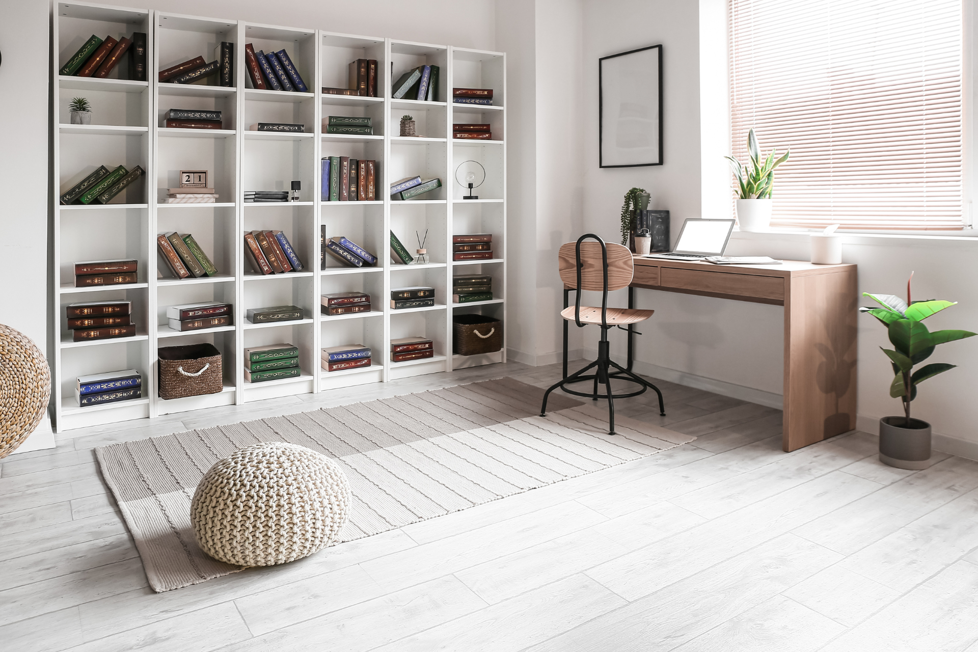 A room with a desk , chair , bookshelves and a window.
