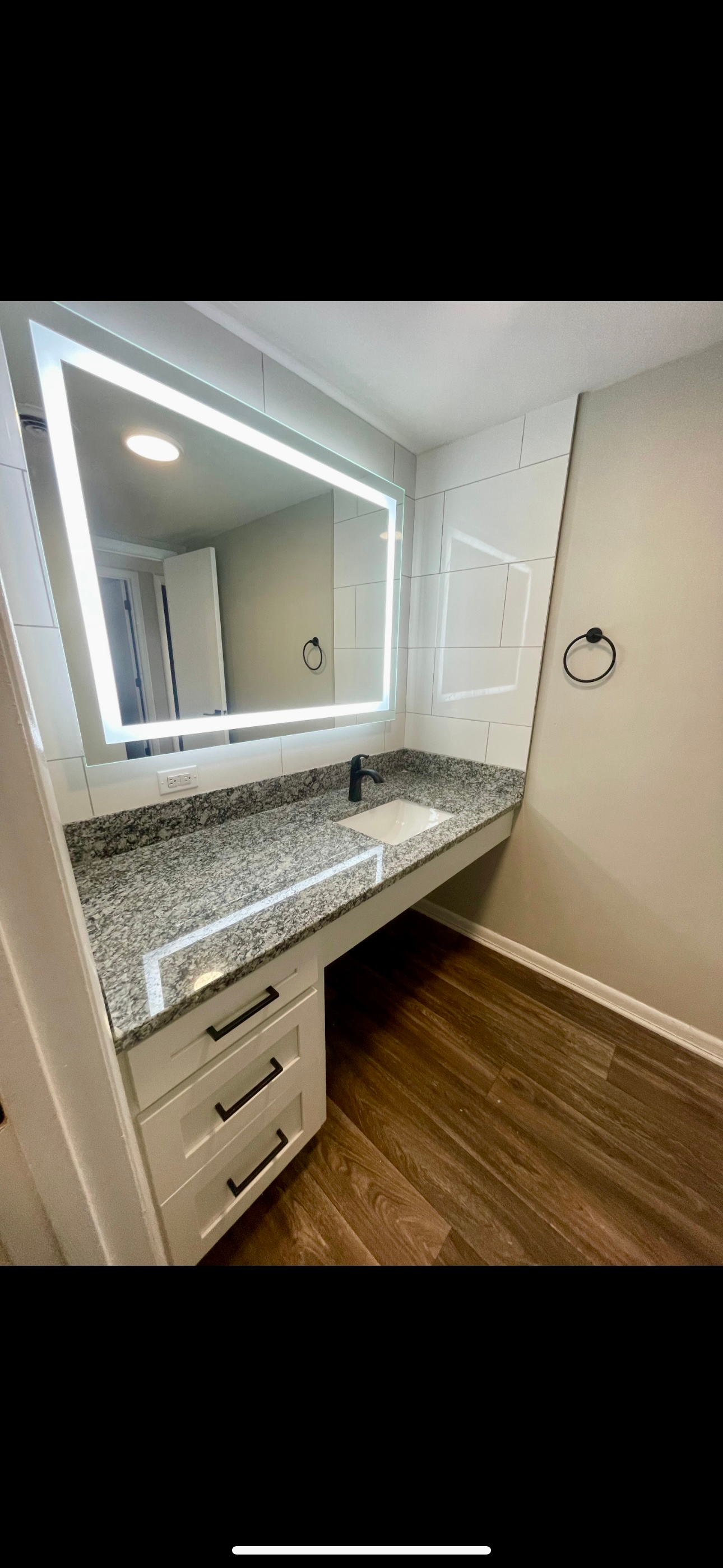 A bathroom with a sink and a large mirror.