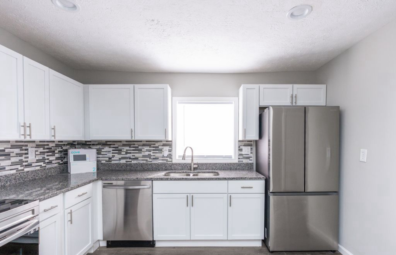 A kitchen with white cabinets and stainless steel appliances