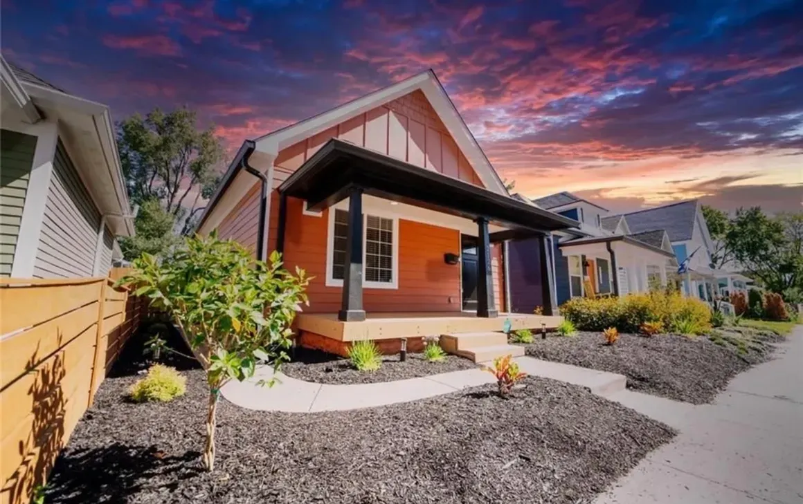 A small house with a porch and a walkway in front of it.