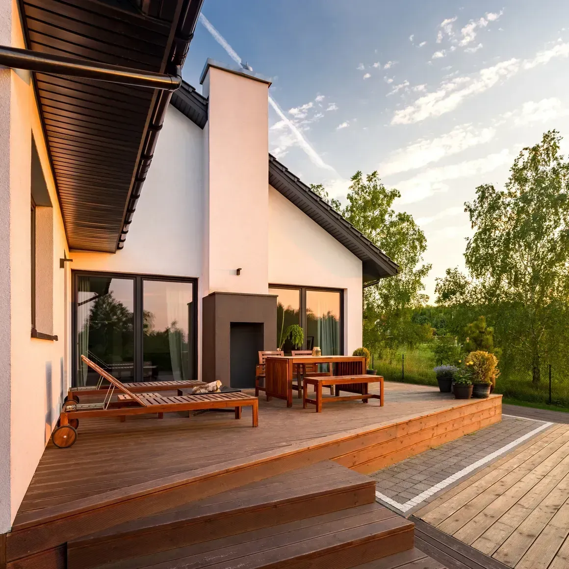 A white house with a wooden deck in front of it