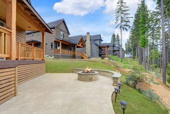 Rustic wooden cabins nestled among tall pine trees, with a cozy outdoor fire pit on a spacious patio. 