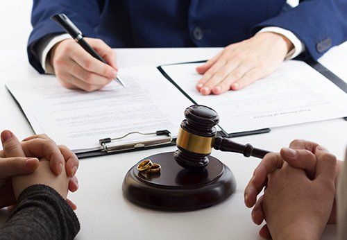 A couple is sitting at a table with a judge 's gavel.