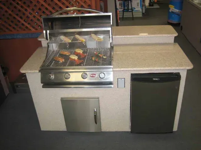 A kitchen with a grill and a refrigerator