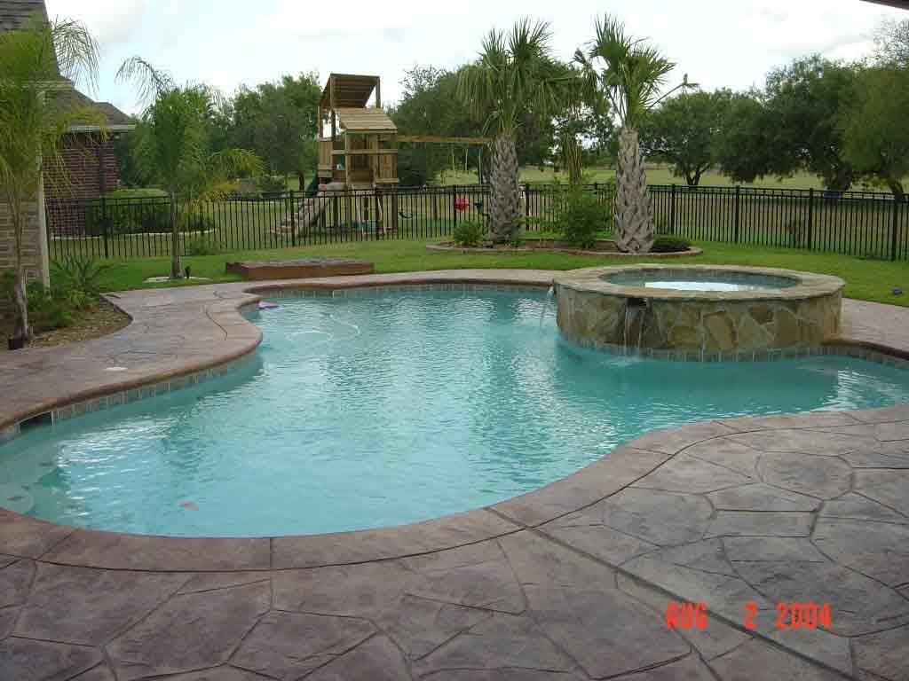 A large swimming pool with a hot tub in the middle