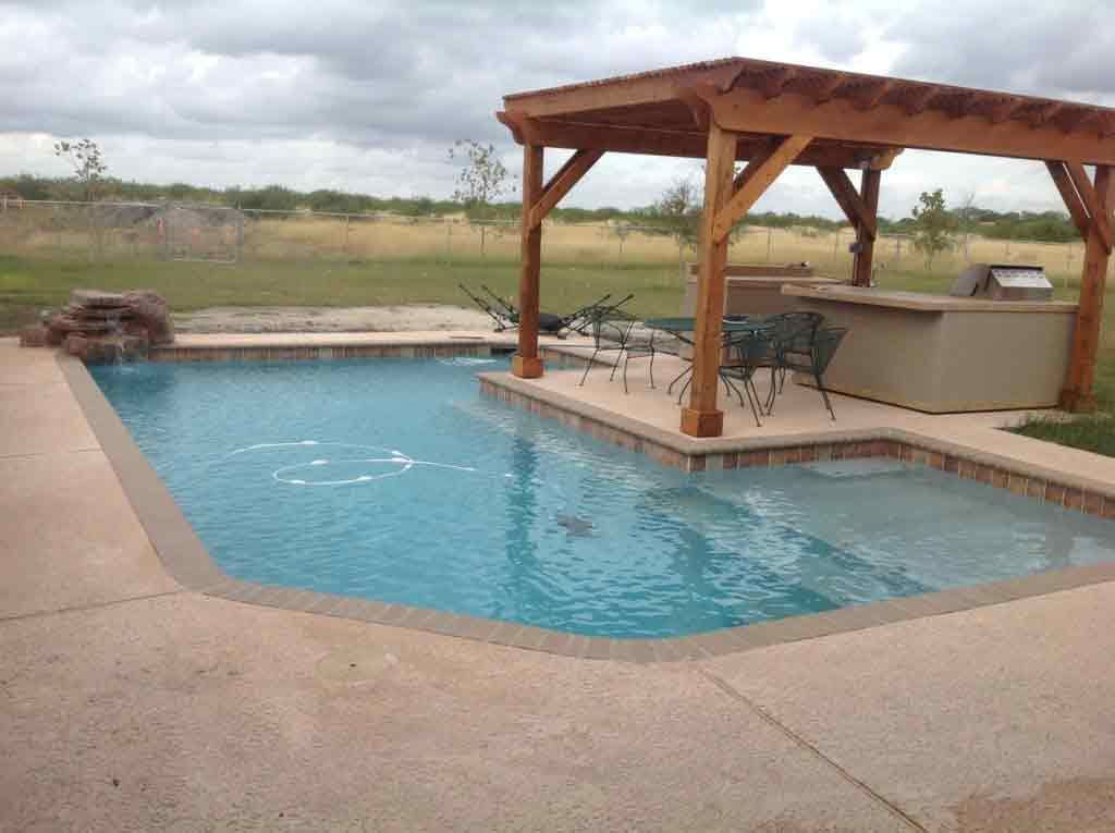 A large swimming pool with a wooden pergola over it