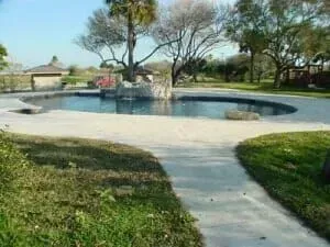 There is a large swimming pool in the middle of the yard.