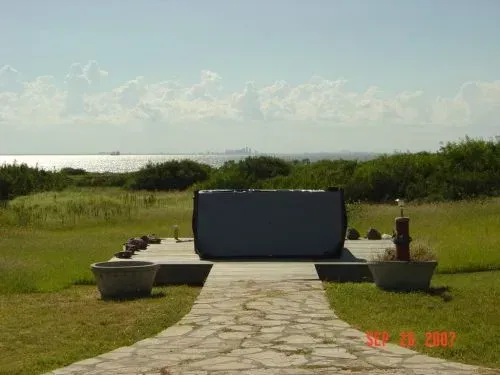 A stone walkway leading to a hot tub with a view of the ocean
