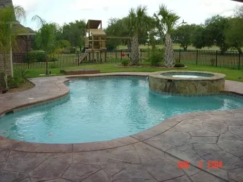 A large swimming pool with a waterfall in the middle