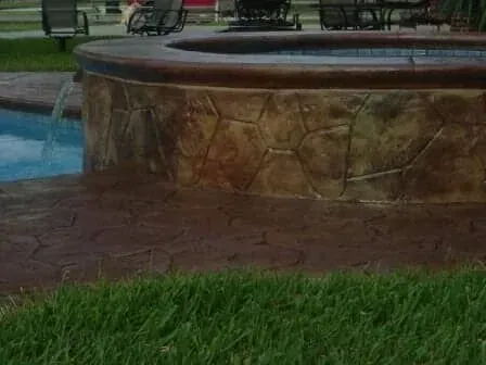 A hot tub is sitting next to a pool in a backyard.