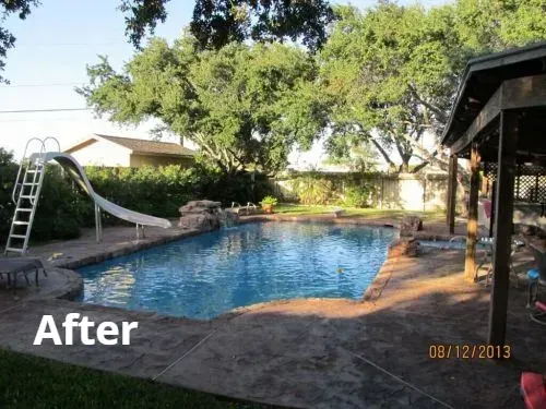 A large swimming pool with a slide in the backyard