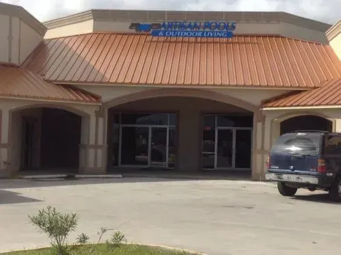 A blue suv is parked in front of a building that says a outside of living
